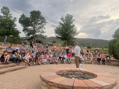 A group of people sit outside in a circle.