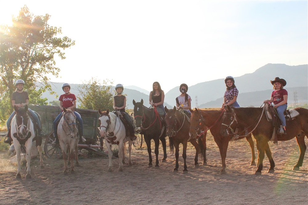 A group of teens on horseback.