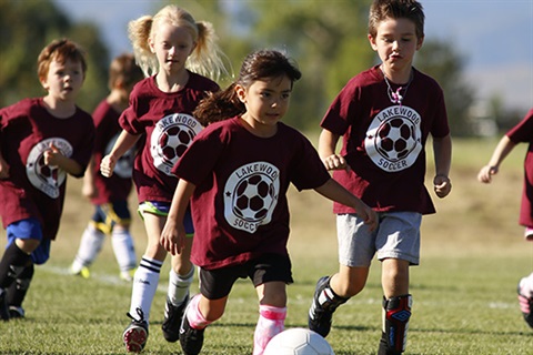 Youth play soccer during a summer camp.