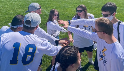 Special Olympics flag football team members meet in their huddle