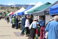 Line of vendors under tents with a crowd of people