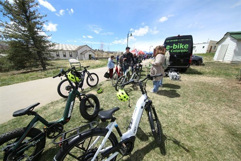 E-bikes parked in the grass next to a bike path