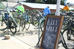 Bike racks full of bikes with a bike valet sign in front of the racks