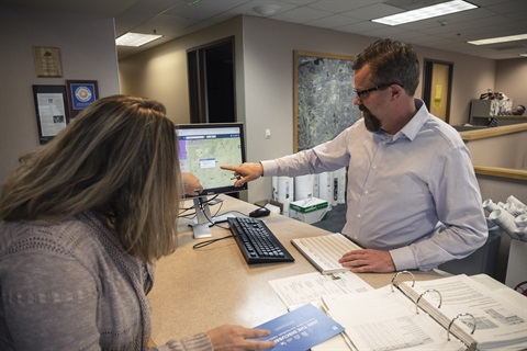 Planner helping a customer at the Planner of the Day counter.